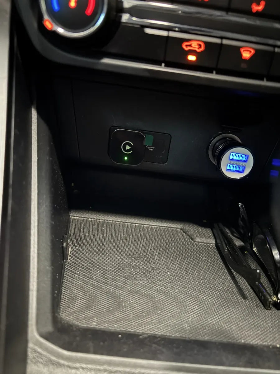 Adaptador CarPlay instalado en la consola del auto con LED encendido
